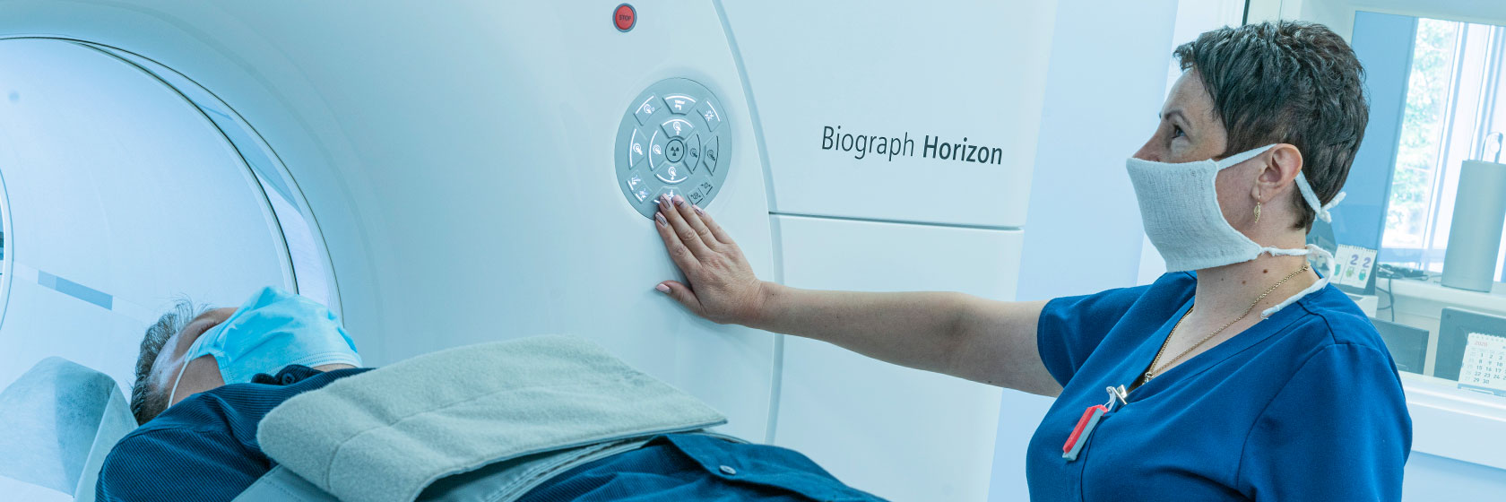 Оператор уложила пациента в аппарат КТ для процедуры компьютерной томографии